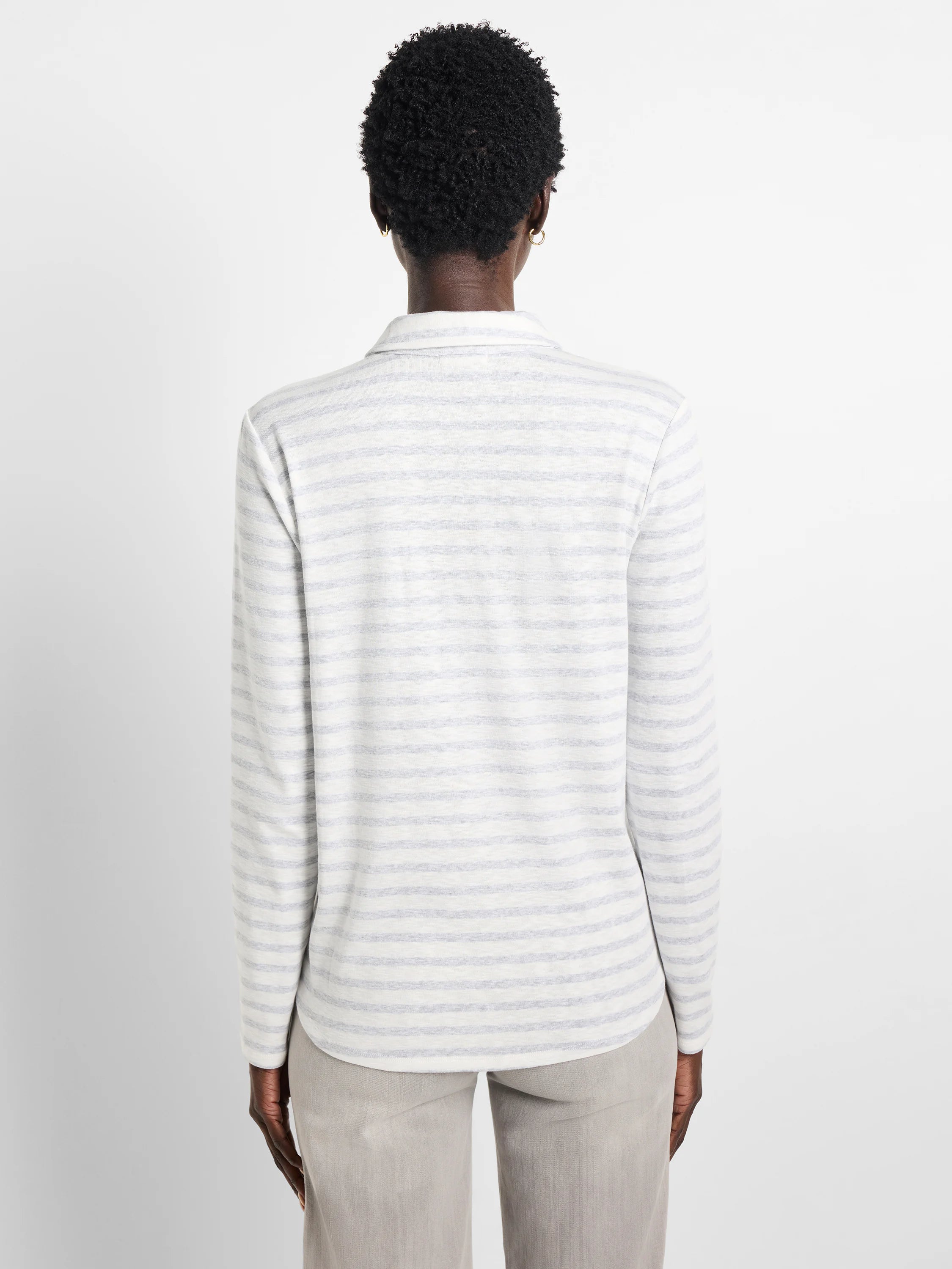White long-sleeve polo shirt with thin, light blue horizontal stripes.  Rear view.