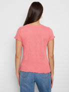Coral pink, textured knit t-shirt. Short sleeves with scalloped edges, and a slightly scalloped hem.