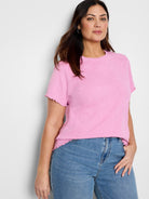 Pink t-shirt with subtle textured floral pattern, short sleeves with ruffled edges.