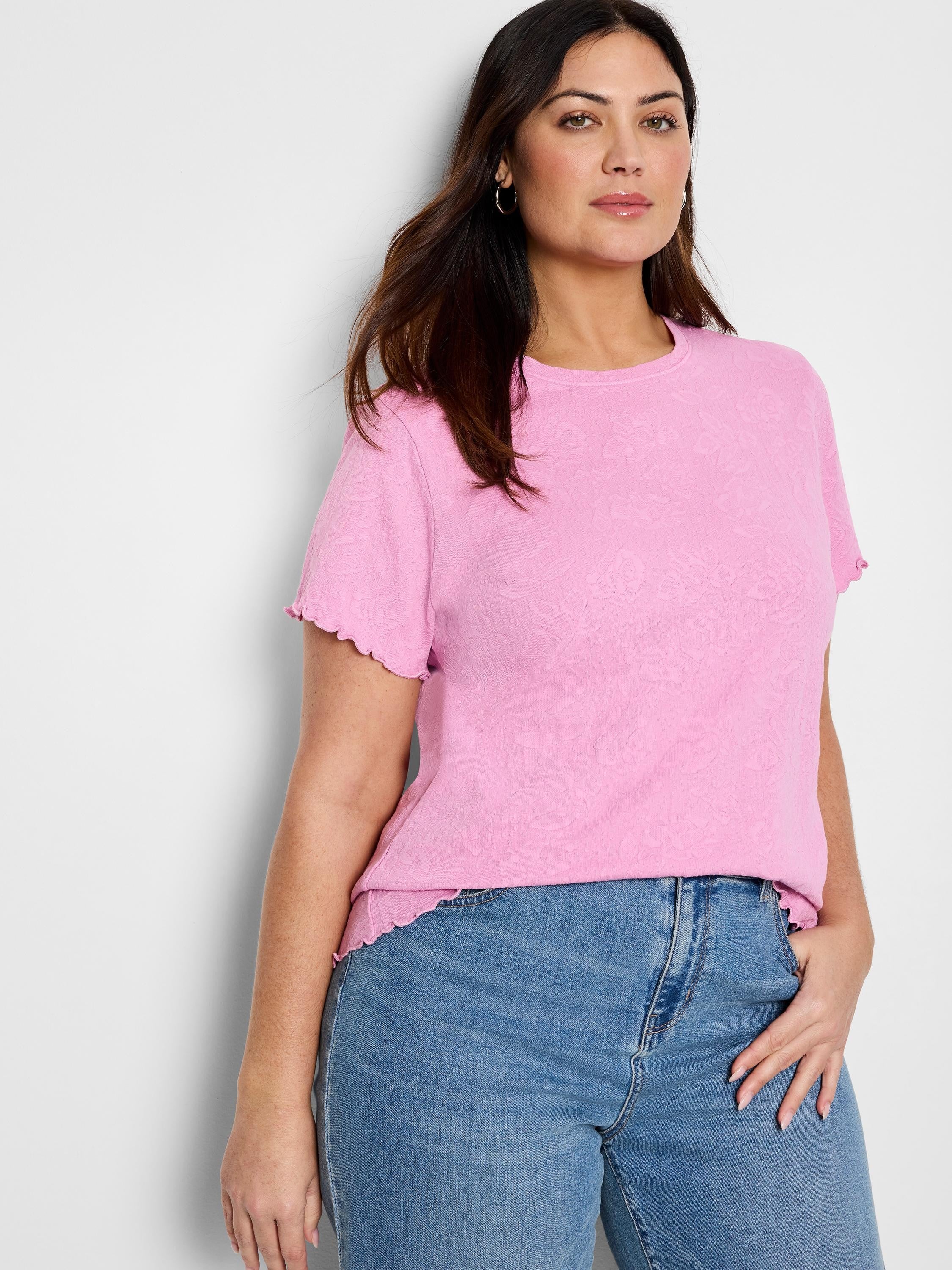 Pink t-shirt with subtle textured floral pattern, short sleeves with ruffled edges.