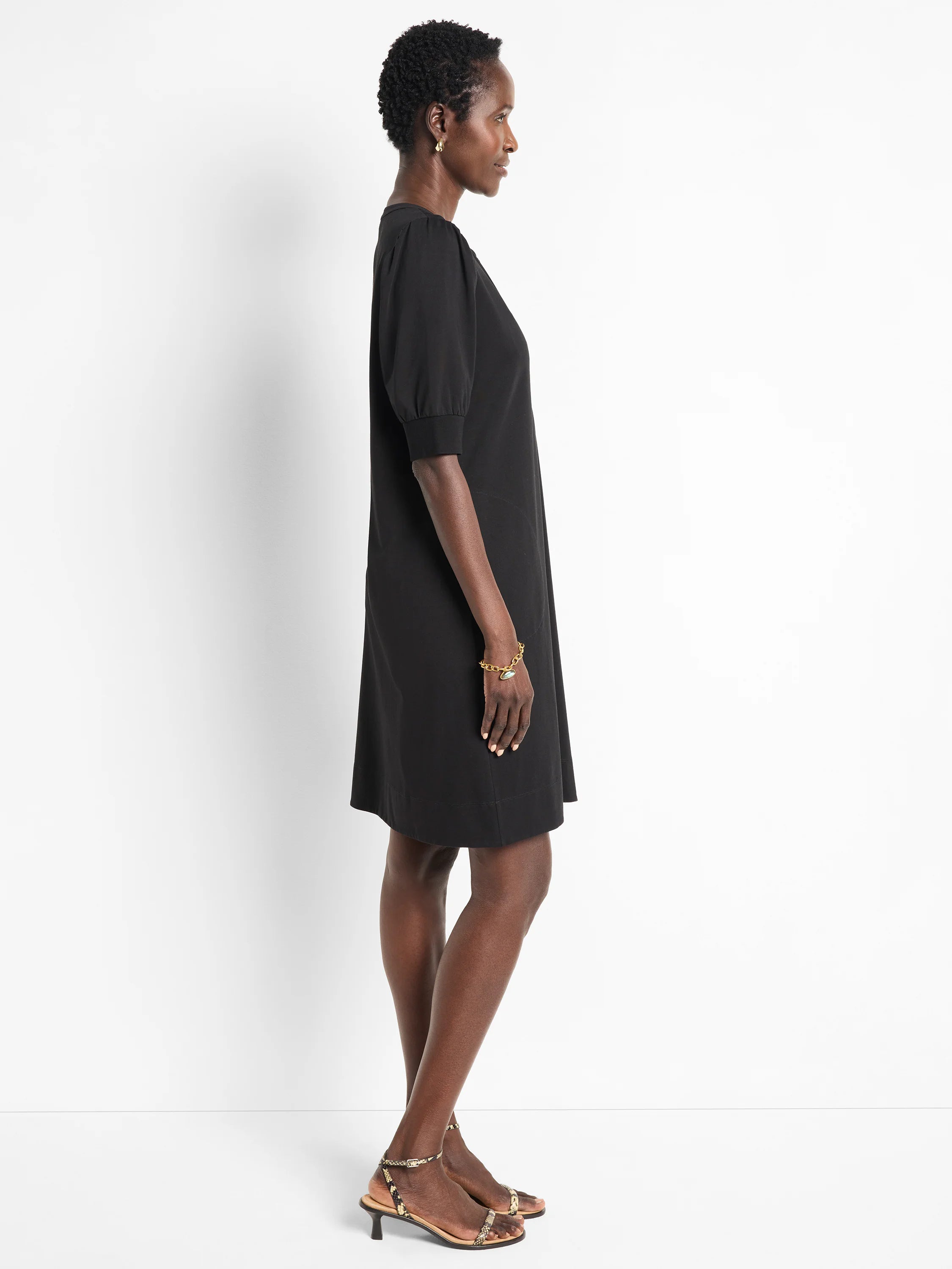 Black Henley dress, short sleeves, knee-length, A-line silhouette.