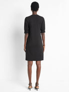 Black short-sleeved Henley dress, puff sleeves, straight hemline.  Rear view.