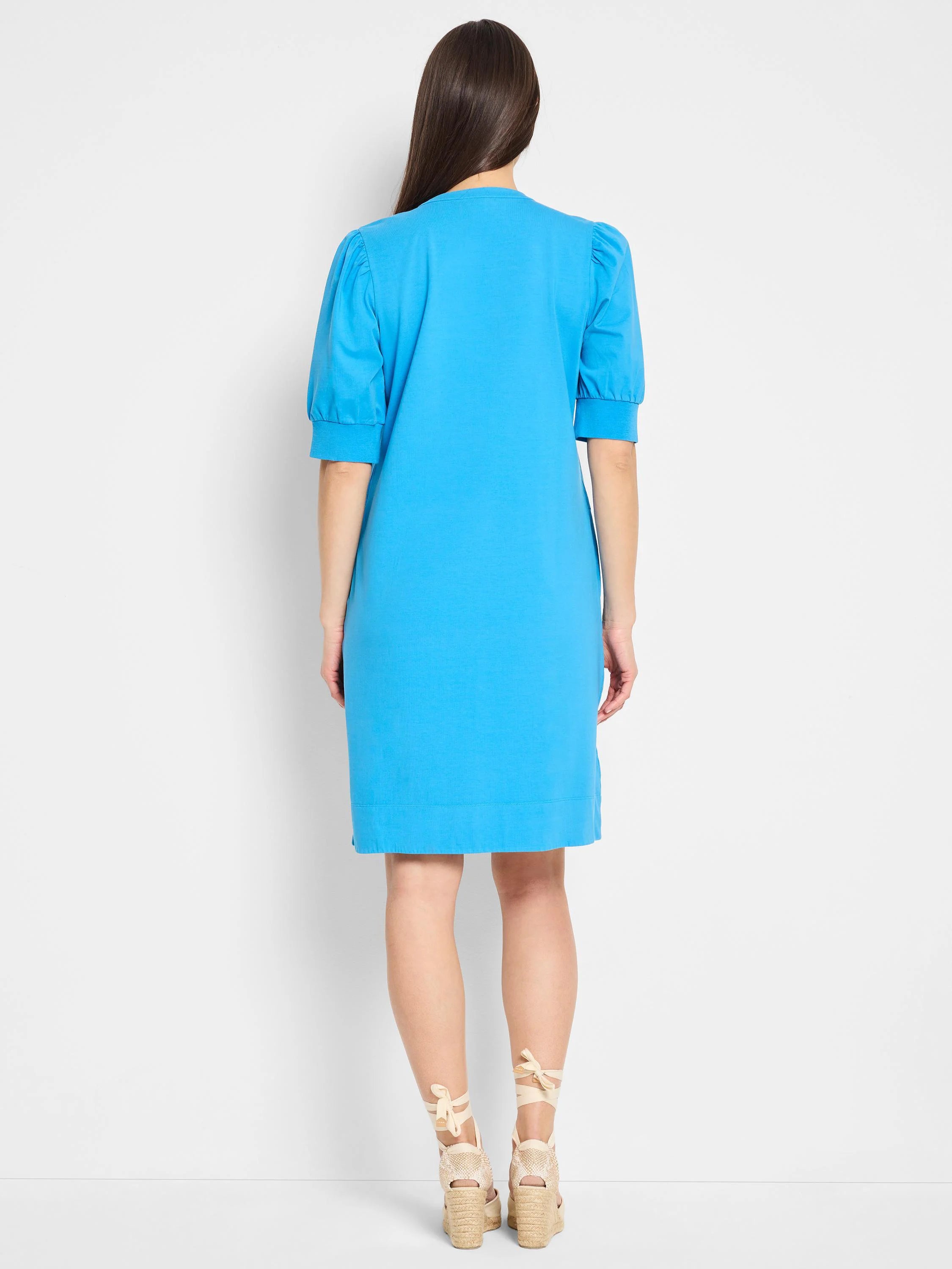Bright blue Henley dress, short sleeves with puff shoulders, midi length.  Back view.