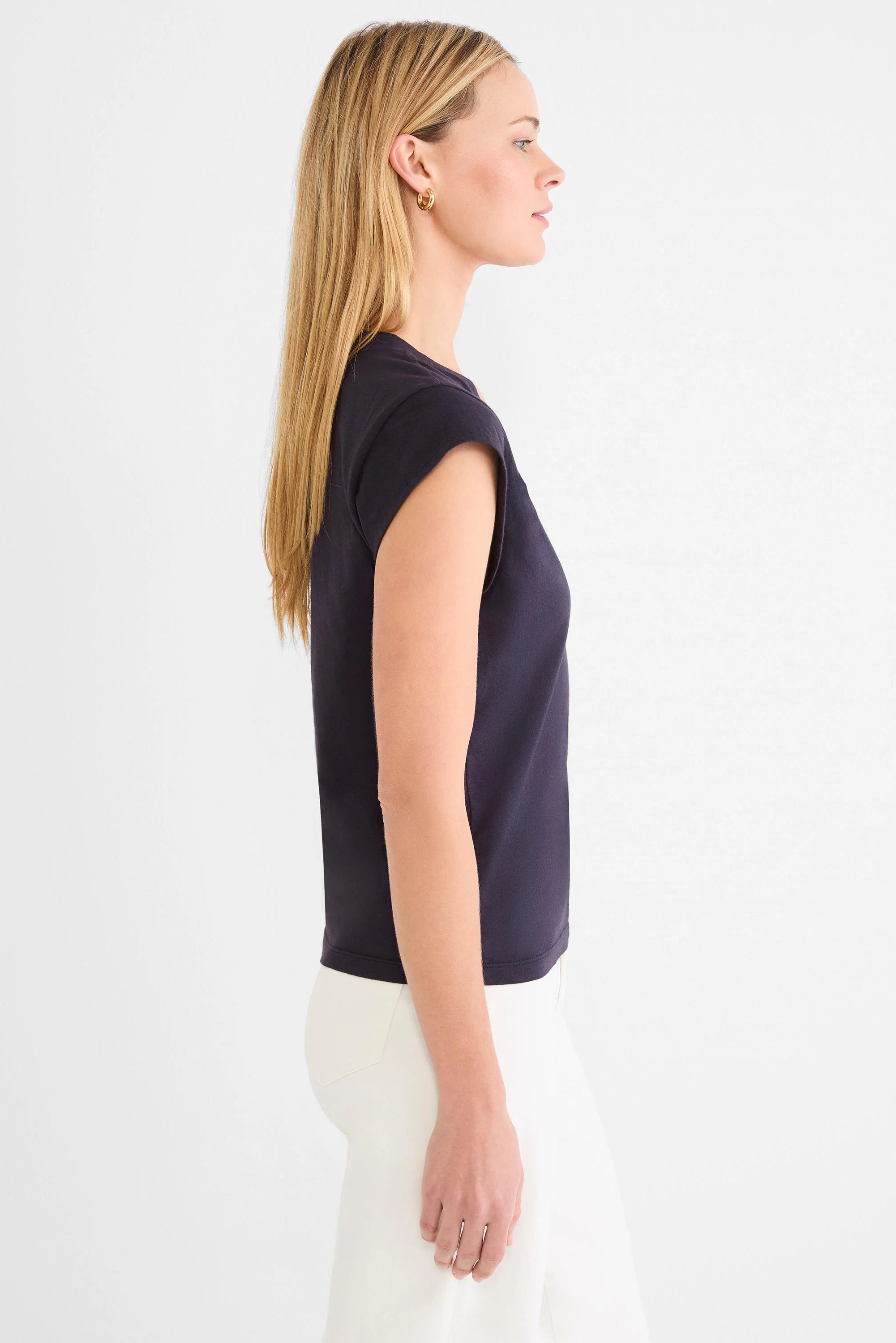 Woman in profile wearing a dark blue cap sleeve V-neck tee. Solid color, fitted style.