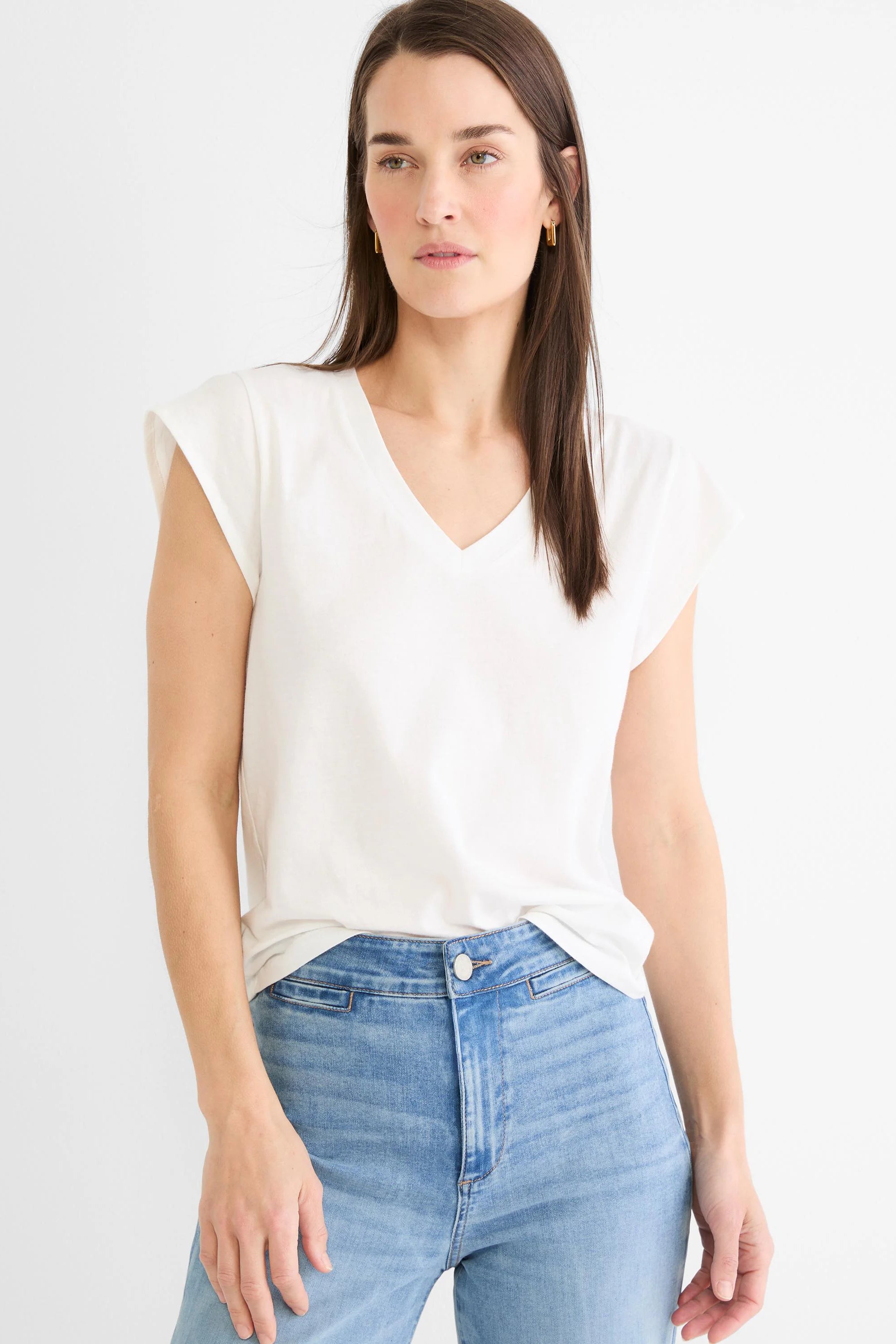 Off-white cap sleeve V-neck tee, shown on model with a relaxed fit, lightly tucked.