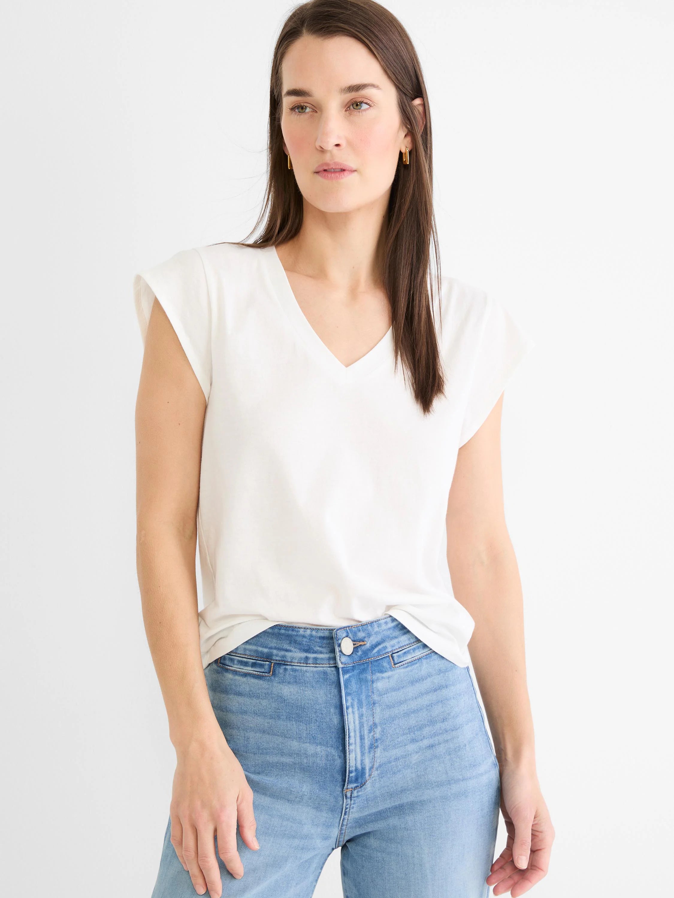 Off-white cap sleeve V-neck tee, shown on model with a relaxed fit, lightly tucked.