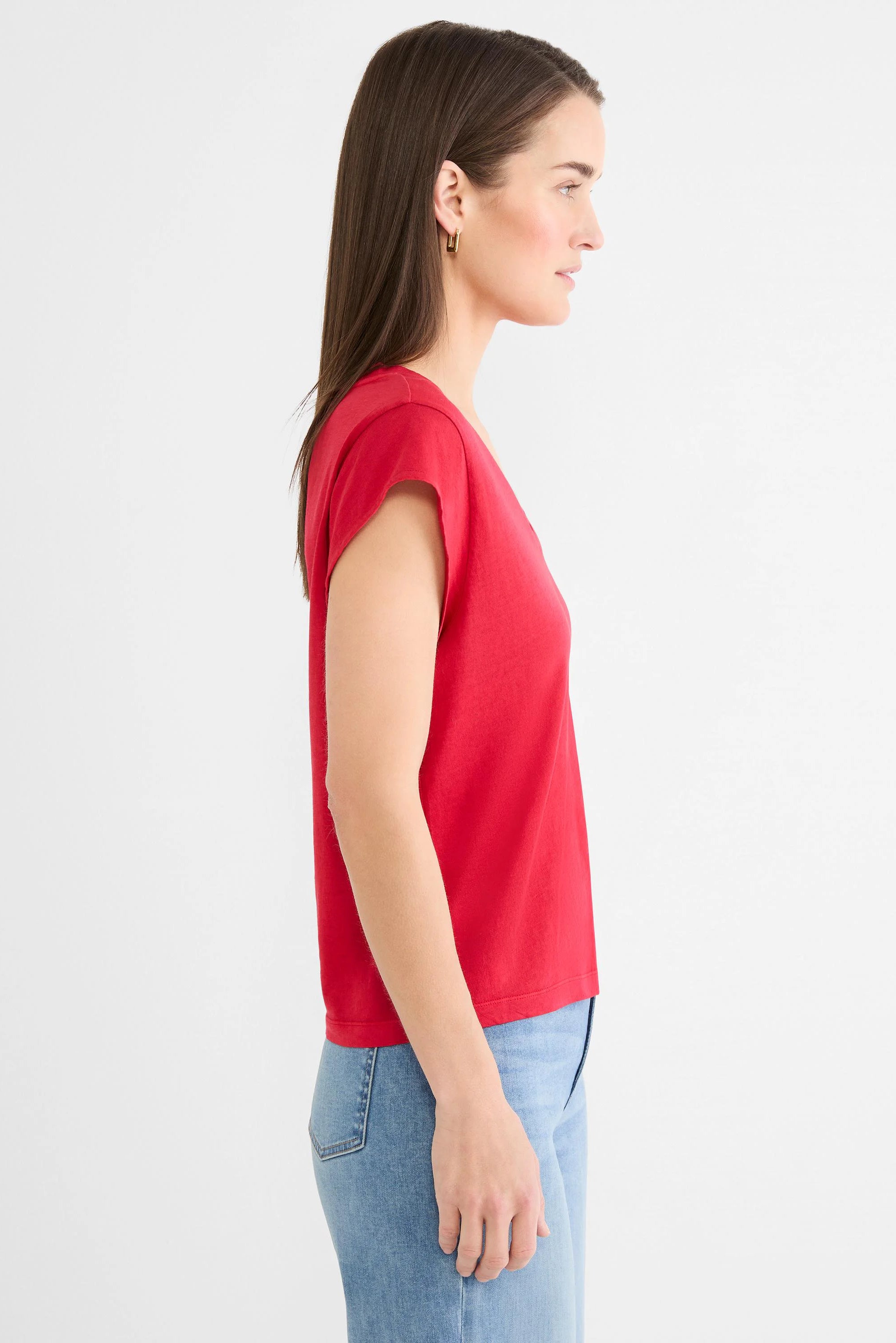 Red cap sleeve V-neck tee on a woman, shown in profile.