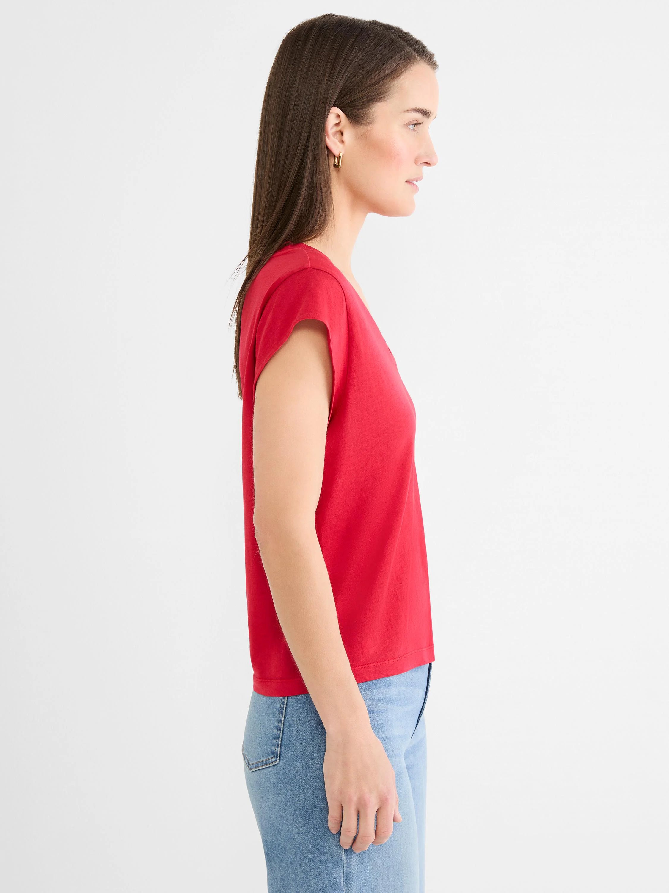 Red cap sleeve V-neck tee on a woman, shown in profile.