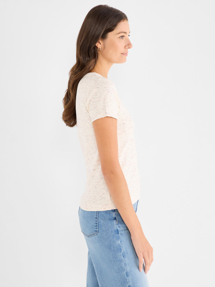 The model wears a fitted cream ribbed short-sleeve tee detailed with a multicolor fleck pattern.