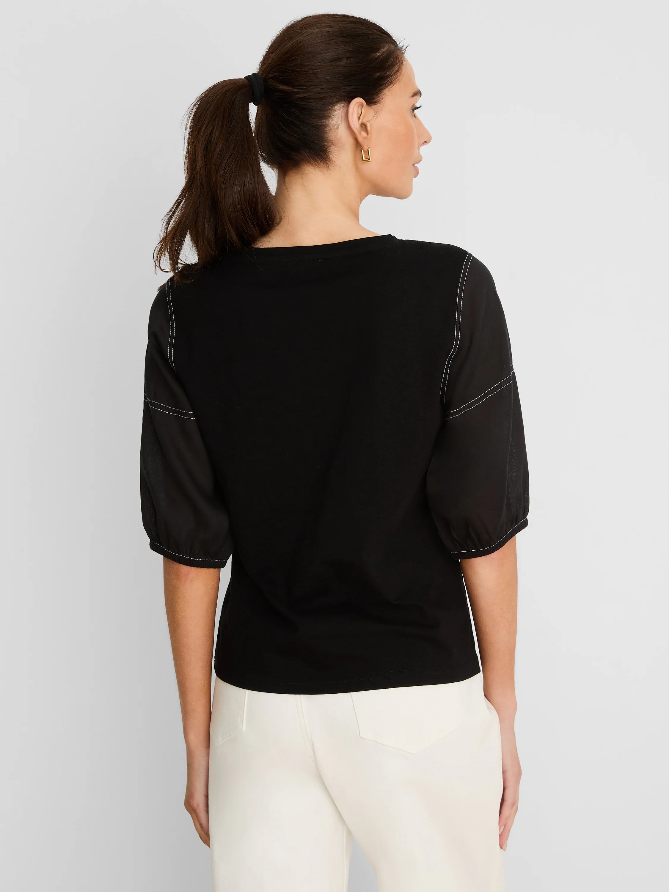 Black cotton tee with sheer linen elbow-length sleeves and white contrast stitching. Back view on model.