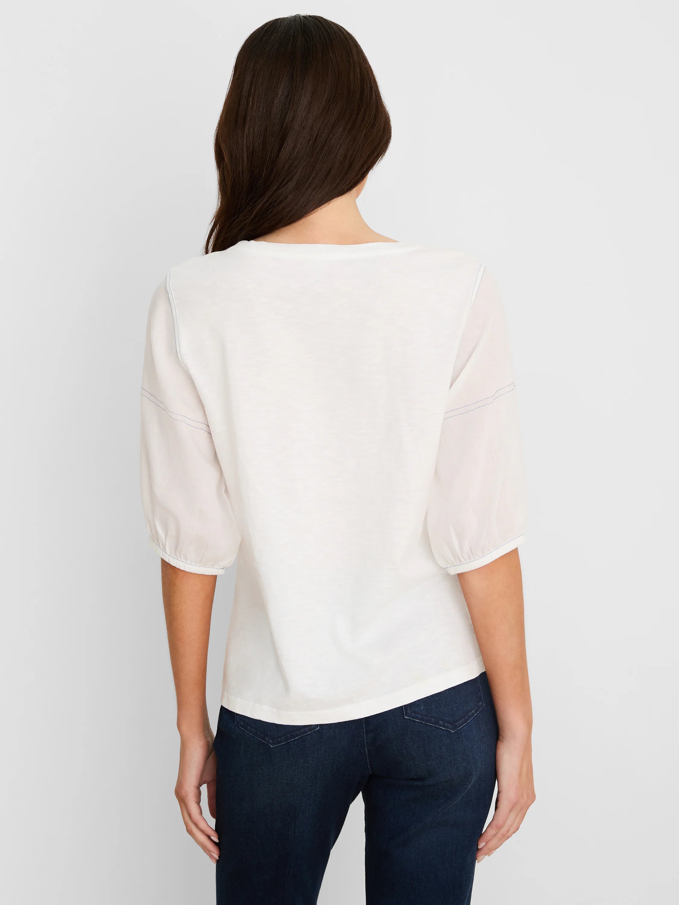 White cotton tee, seen from back. Features sheer, elbow-length linen sleeves with gathered cuffs and visible blue stitching.
