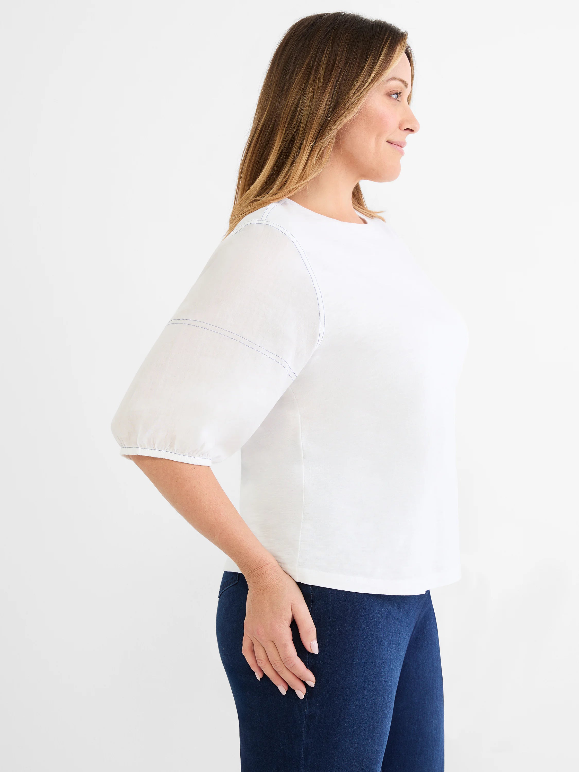 White top with round neck. Features elbow-length linen sleeves gathered at the cuff and exposed blue stitching.