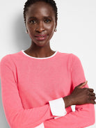 Pink double-layered sweater with white inner cuffs and neckline. Long sleeves, crew neck.