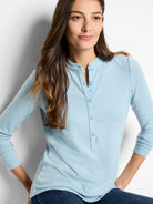 Light blue long-sleeve henley shirt with a placket of small buttons.