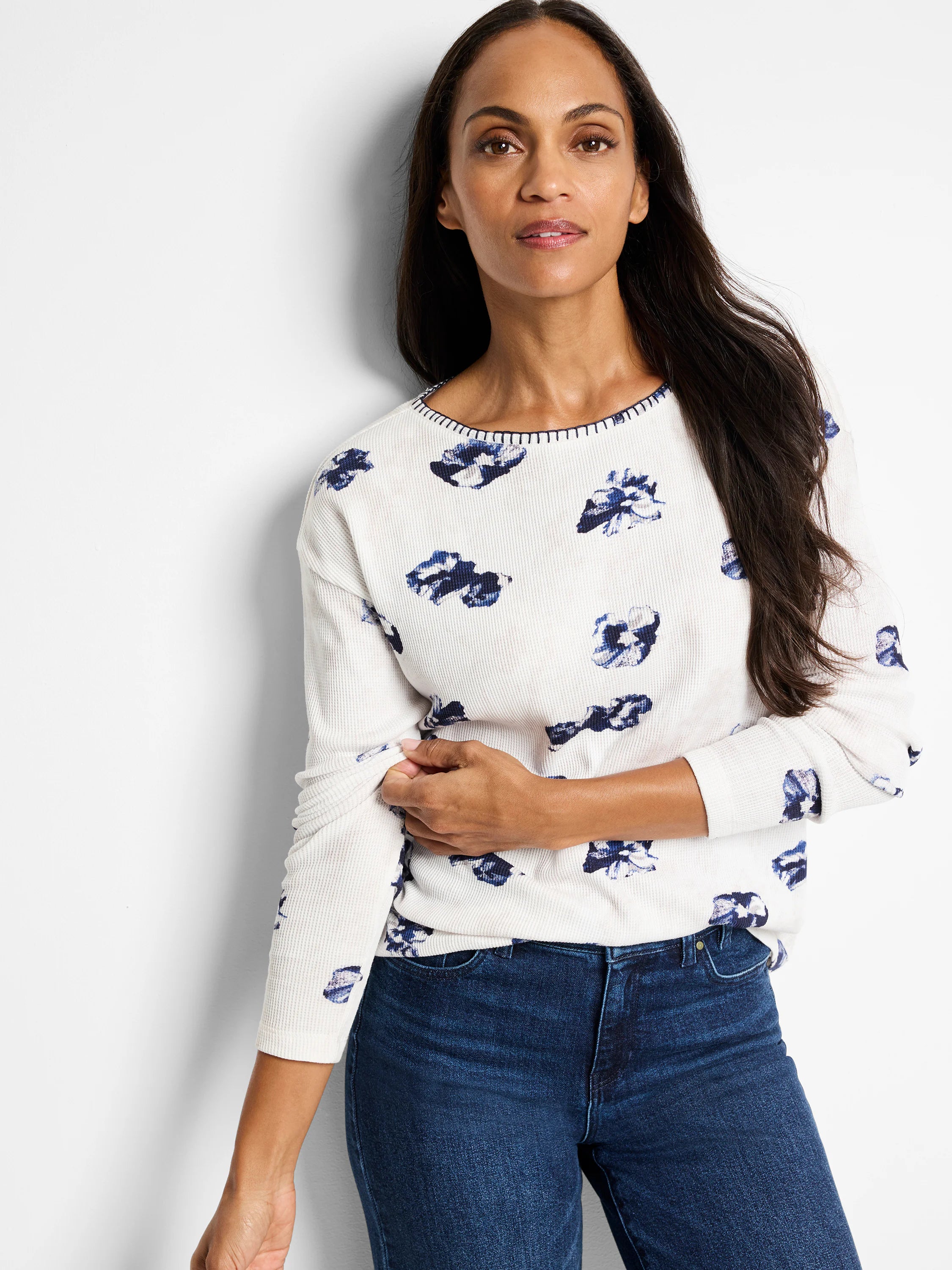 Off-white waffle-knit long-sleeve tee with a scattered blue floral print and dark blue stitching at neckline.