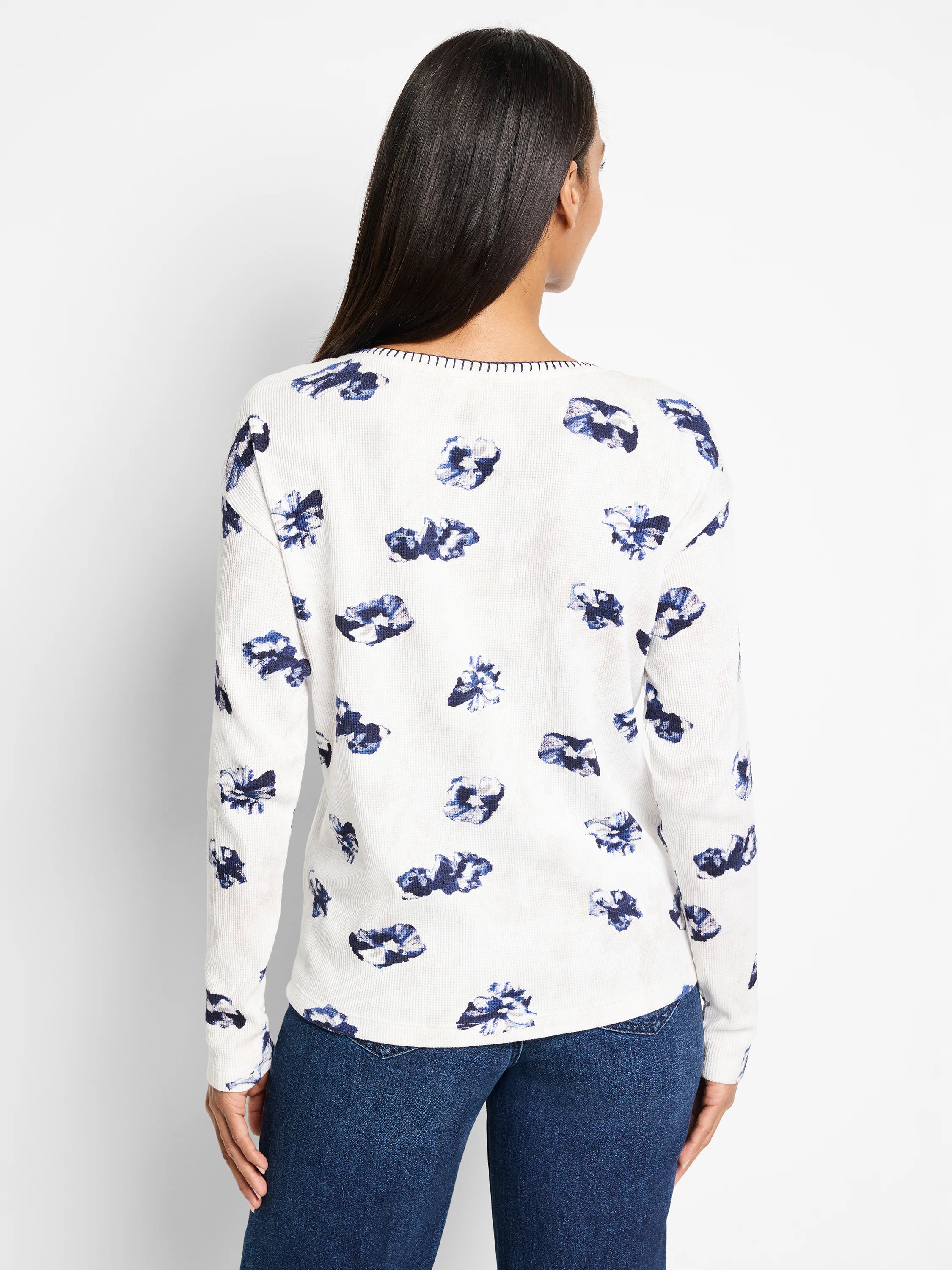 White waffle-knit long-sleeve shirt with a scattered blue floral pattern.  Features a subtle neckline detail.
