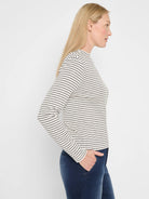 Off-white long-sleeve mock neck tee with narrow dark gray horizontal stripes.