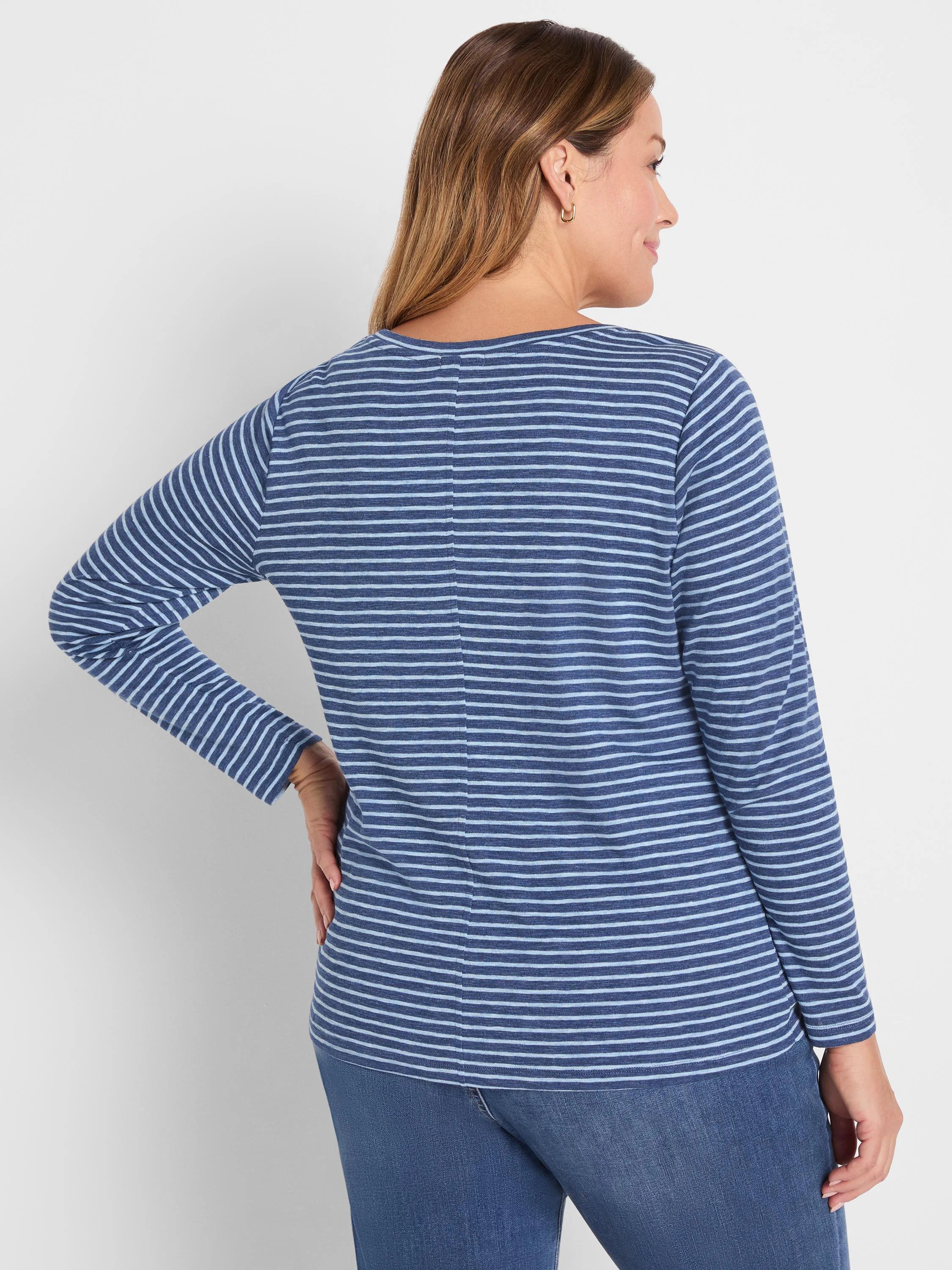 Model wears a long-sleeve boat neck tee with navy and light blue horizontal stripes. Back view.