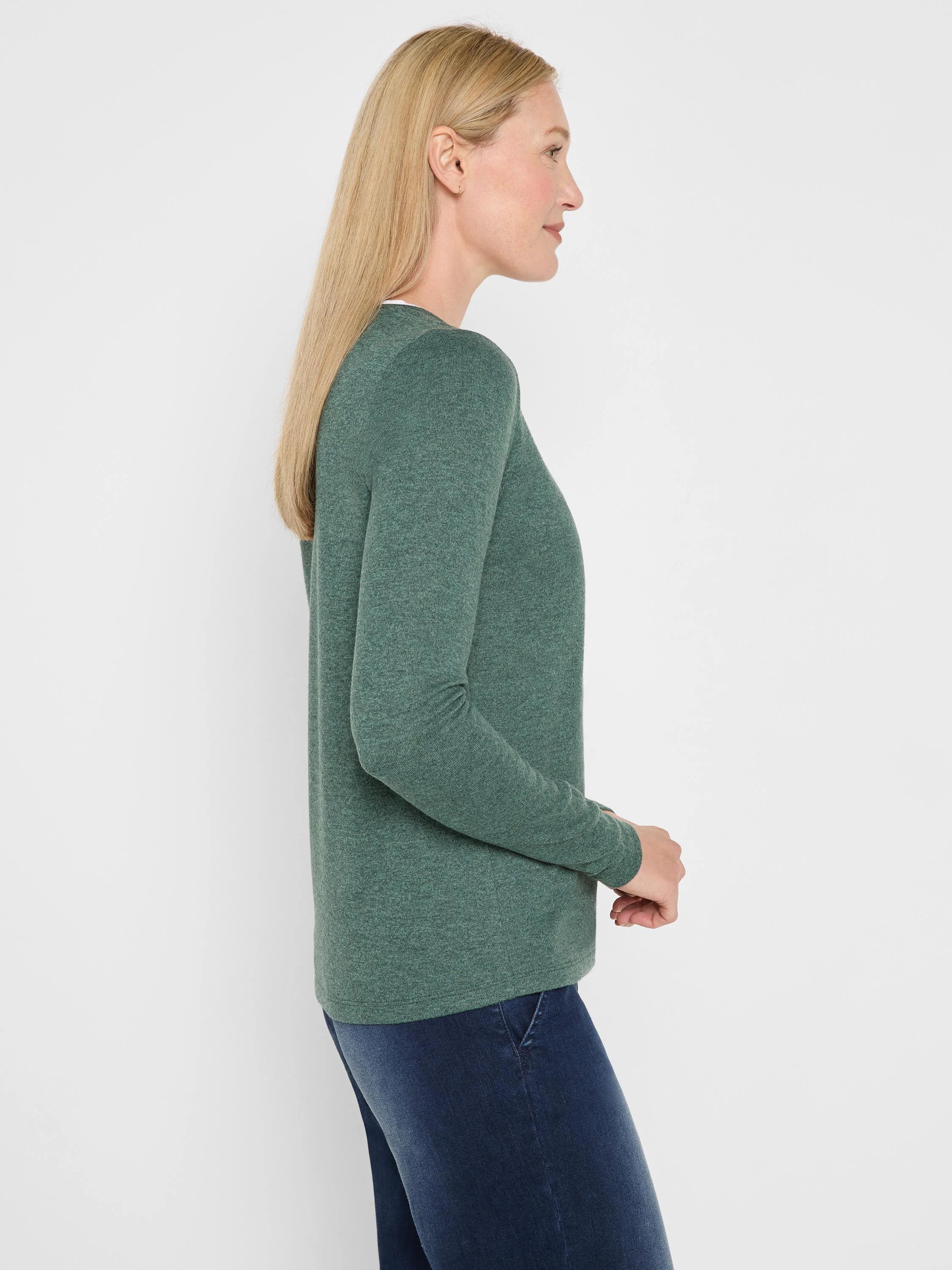 Heathered dark green long-sleeve jersey tee on woman, side profile, with a visible double-layer neckline.