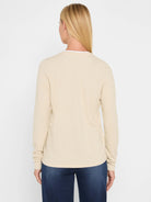 Light beige jersey long-sleeve tee, back view. Features a double-layer neckline with a white underlayer.