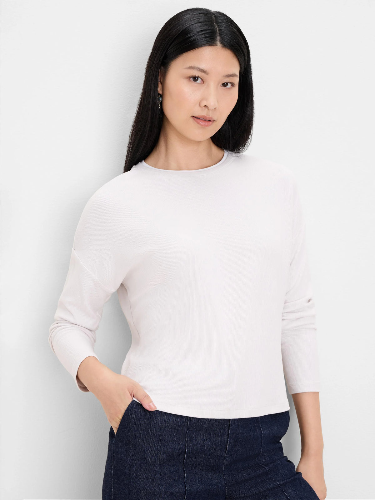 Pale cream ribbed top with round neck, long sleeves, and double-layer neckline detail.