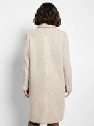 Beige wool topcoat with herringbone pattern.  Features a lighter beige trim. Shown from the back.
