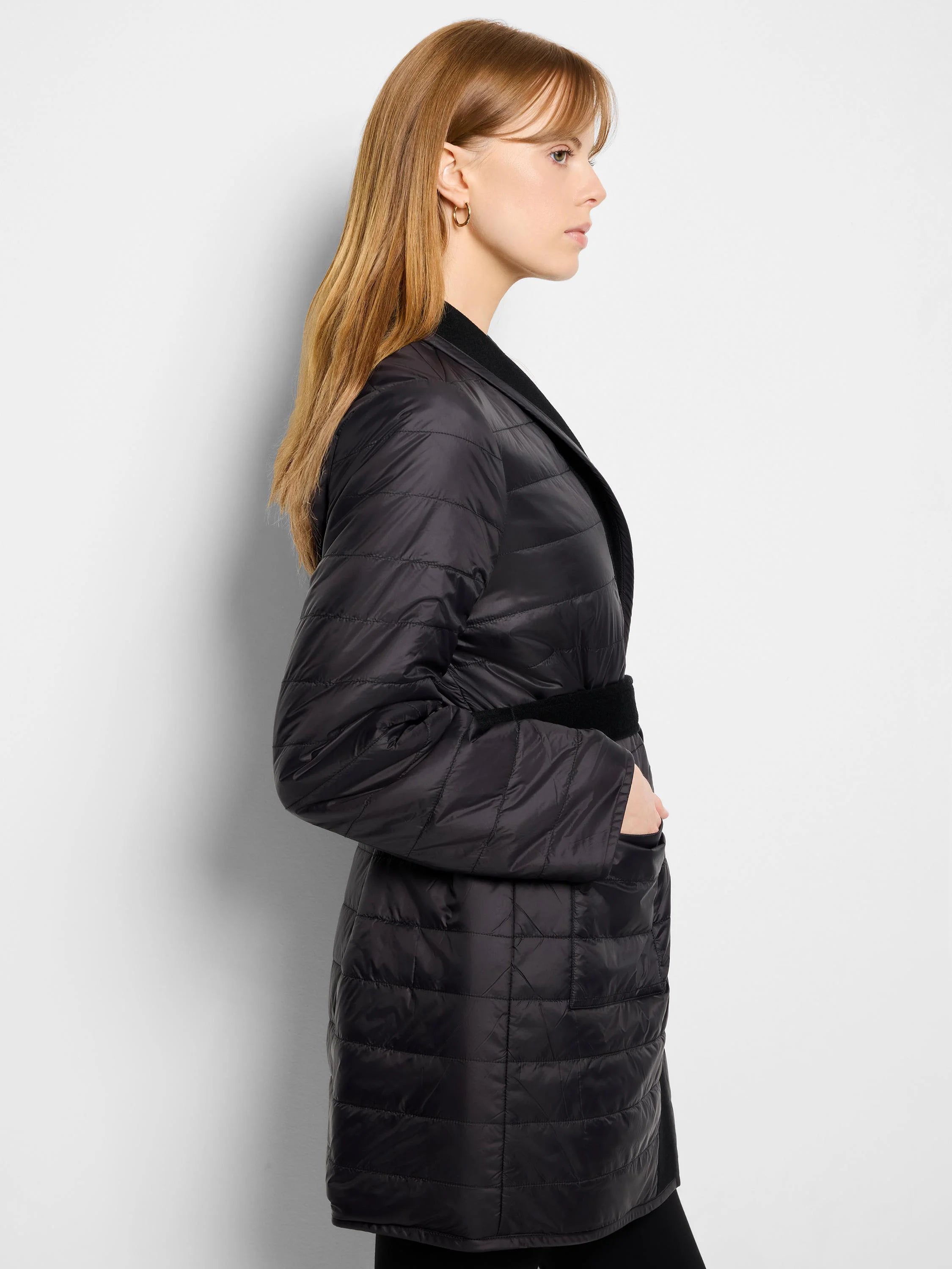 Black quilted wool top coat with self-tie belt.  Features horizontal quilting and a dark inner collar.