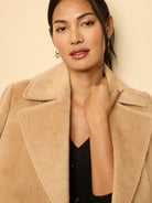 Camel wrap coat with a soft, fuzzy texture and wide lapels.