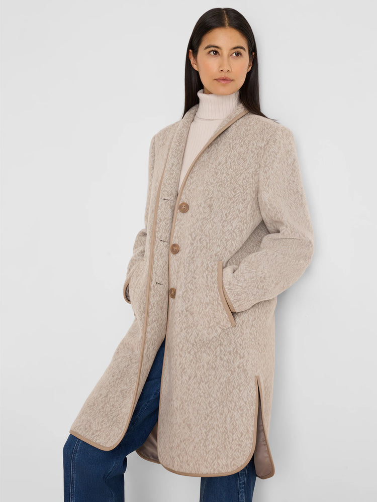 Light beige long coat with a jacquard herringbone pattern, tan piping, buttons, and side pockets.
