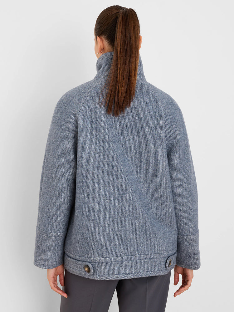 Back view of a muted blue-grey wool coat with a high stand collar and two dark buttons on the wide hem.