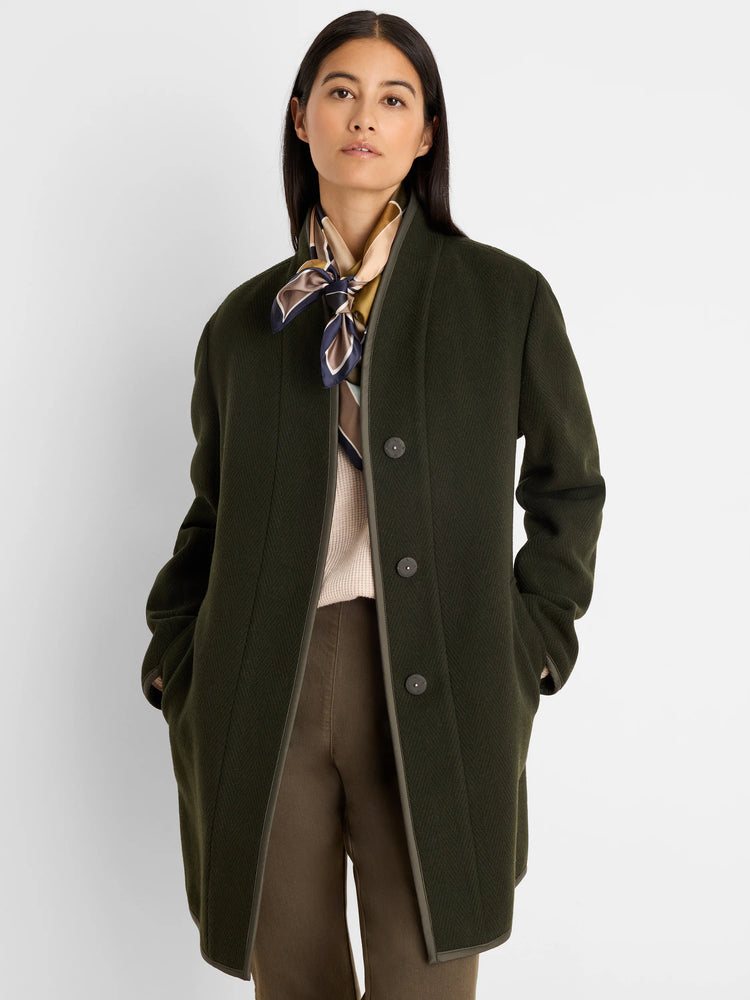 Dark green reversible wool top coat, collarless, with subtle herringbone texture. Lighter olive trim and buttons.