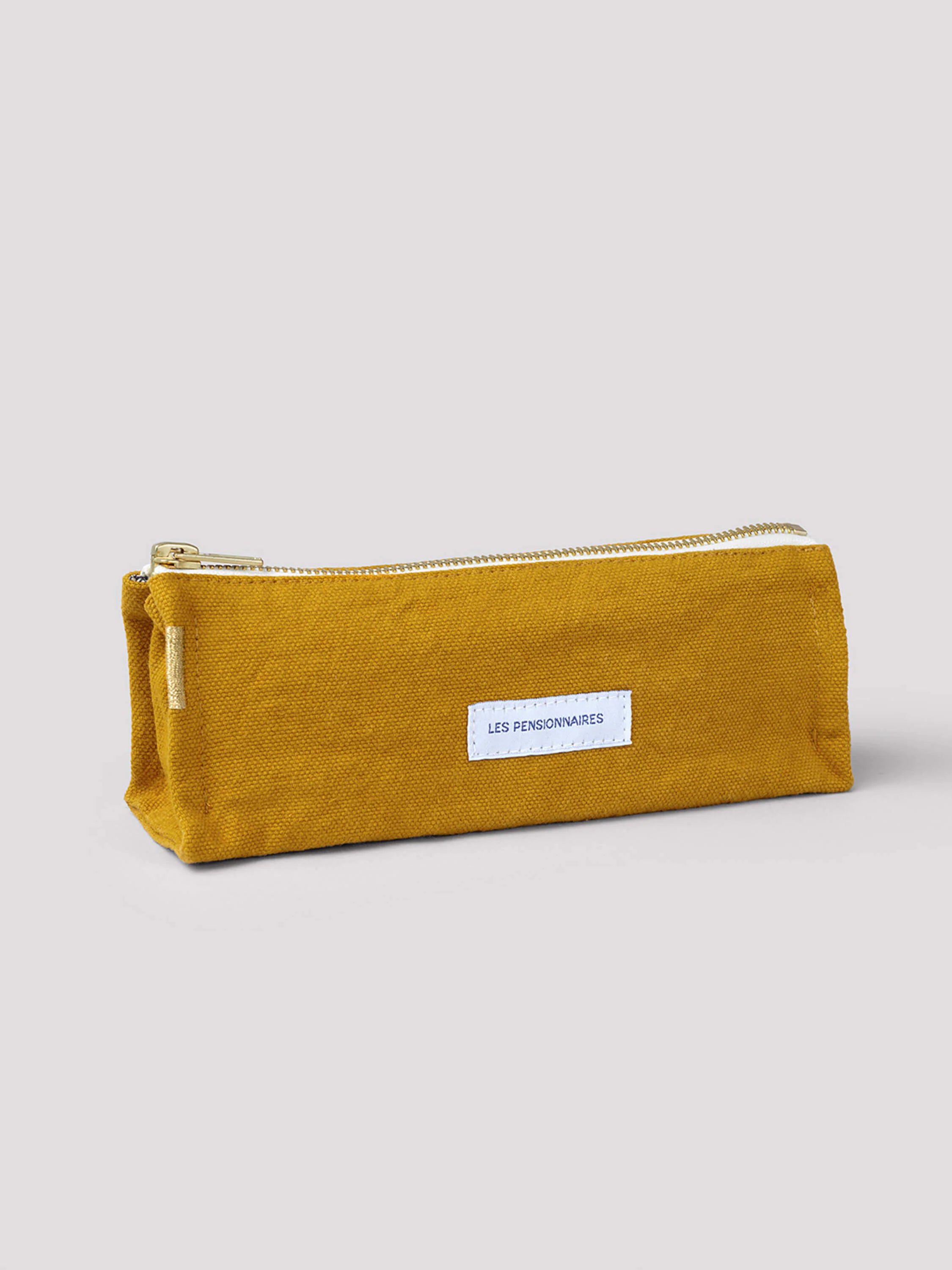 Mustard yellow cotton pencil case with gold zipper and small white label.