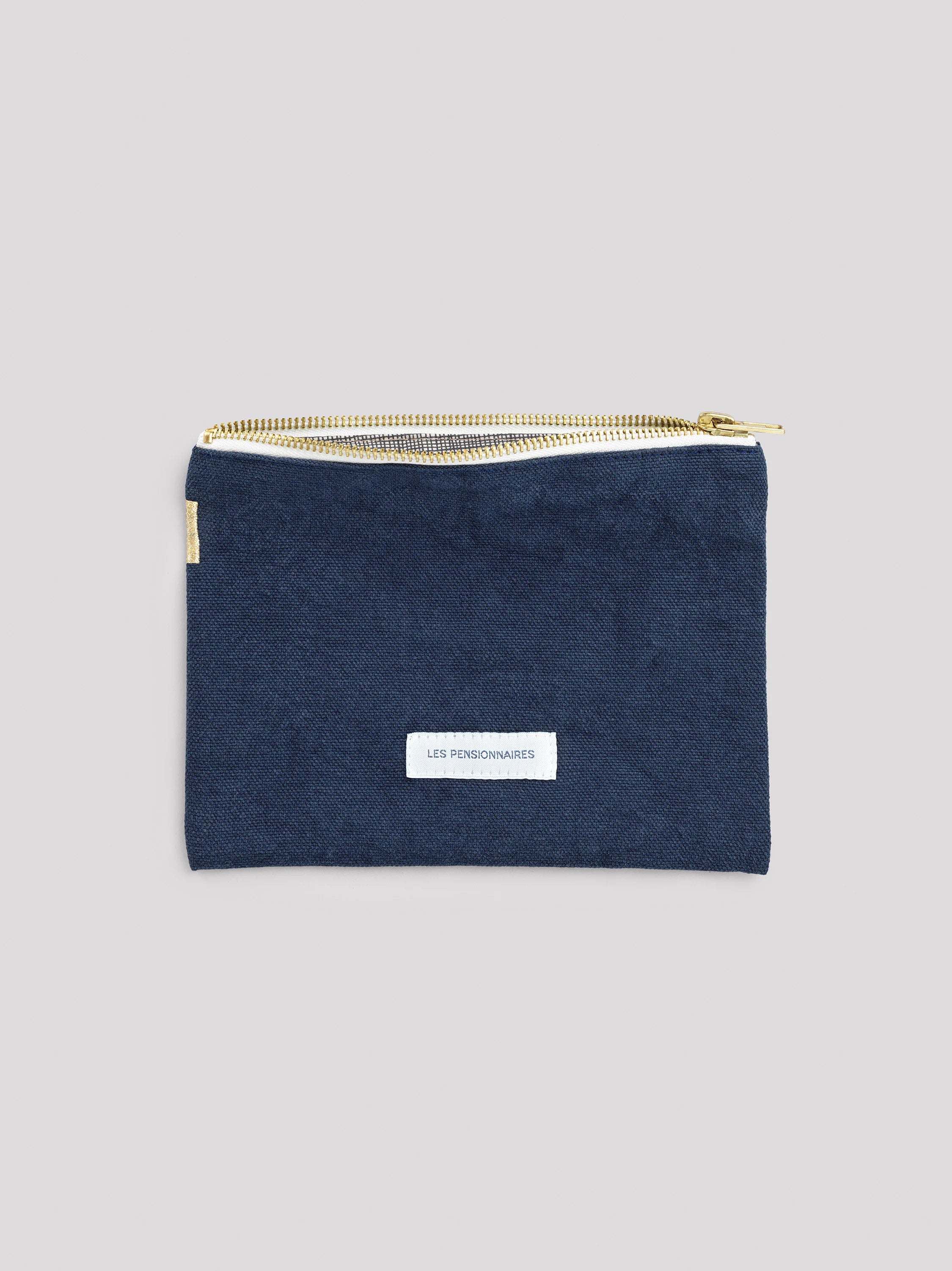 Navy cotton small zipper pouch with gold zipper. White "LES PENSIONNAIRES" label on front, small gold bar on left edge.