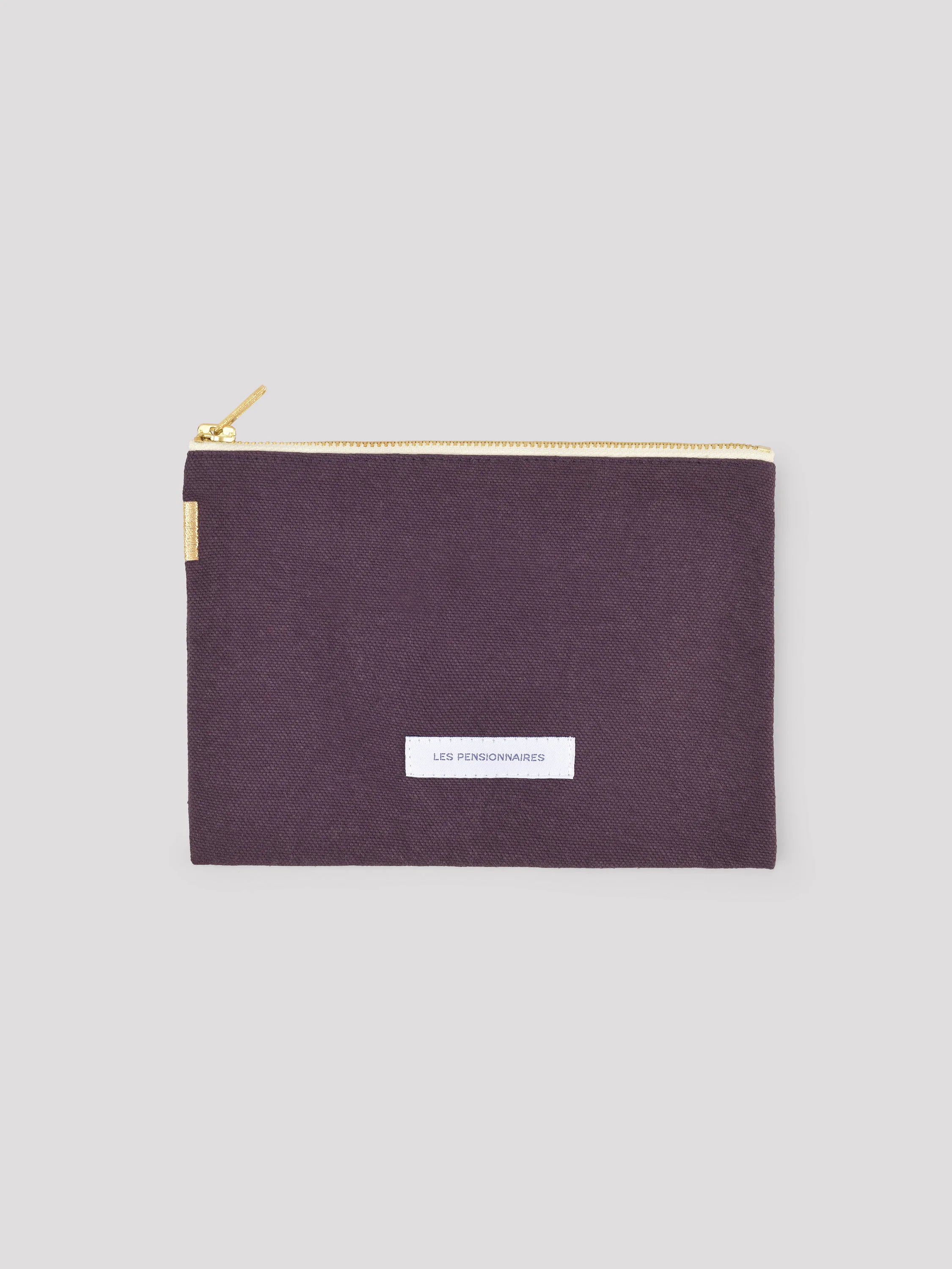 Dark purple cotton pouch with gold zipper and a white "LES PENSIONNAIRES" label on front.