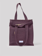 Plum cotton tote bag with two top handles, a gold zipper, and a white 'Les Pensionnaires' label.