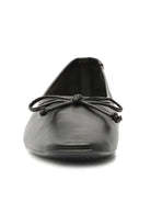 Black flat shoe with a squared toe and a knotted bow.