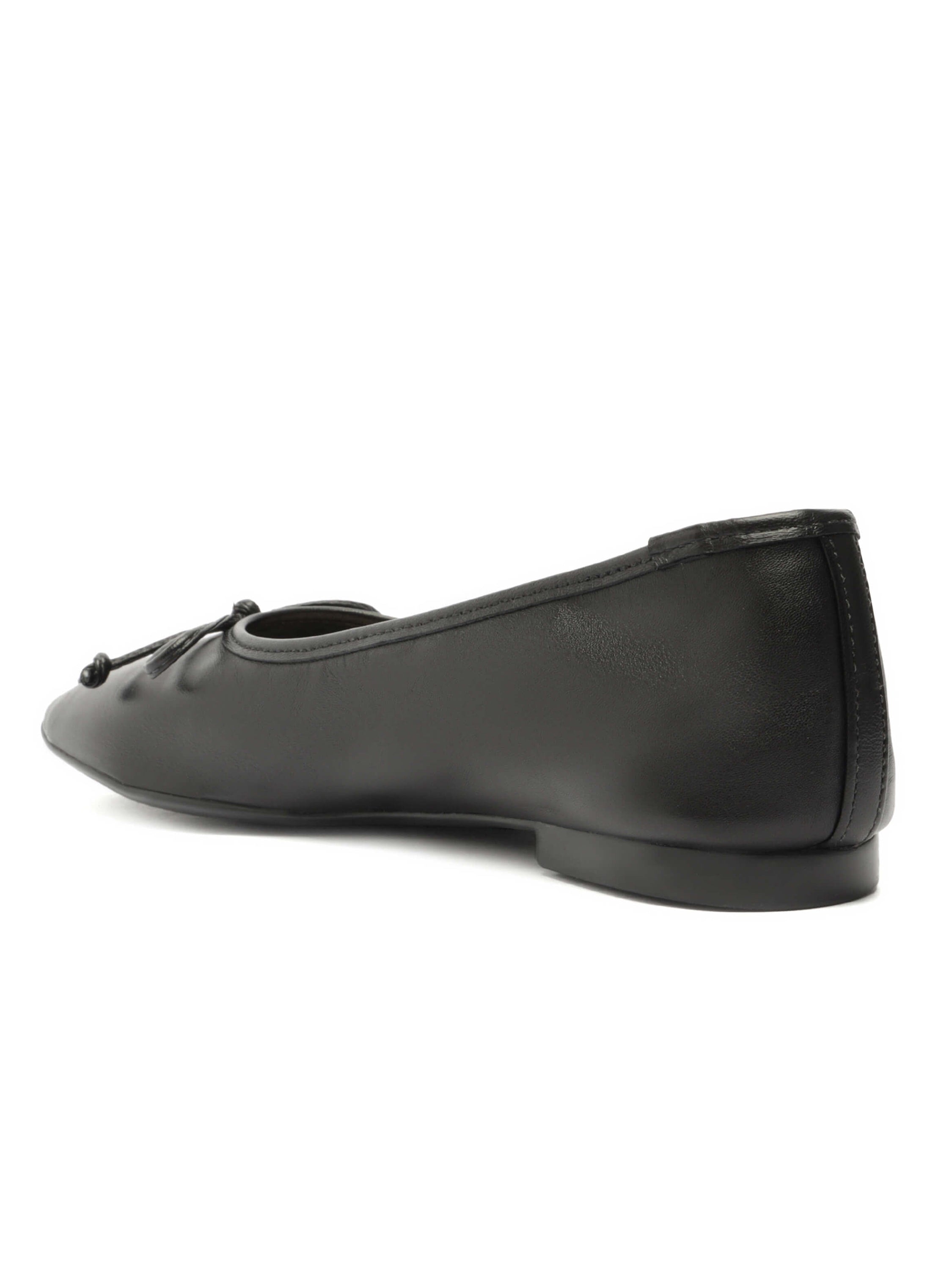 Black leather square-toe ballet flats offer a low heel and a small decorative knot detail at the vamp.