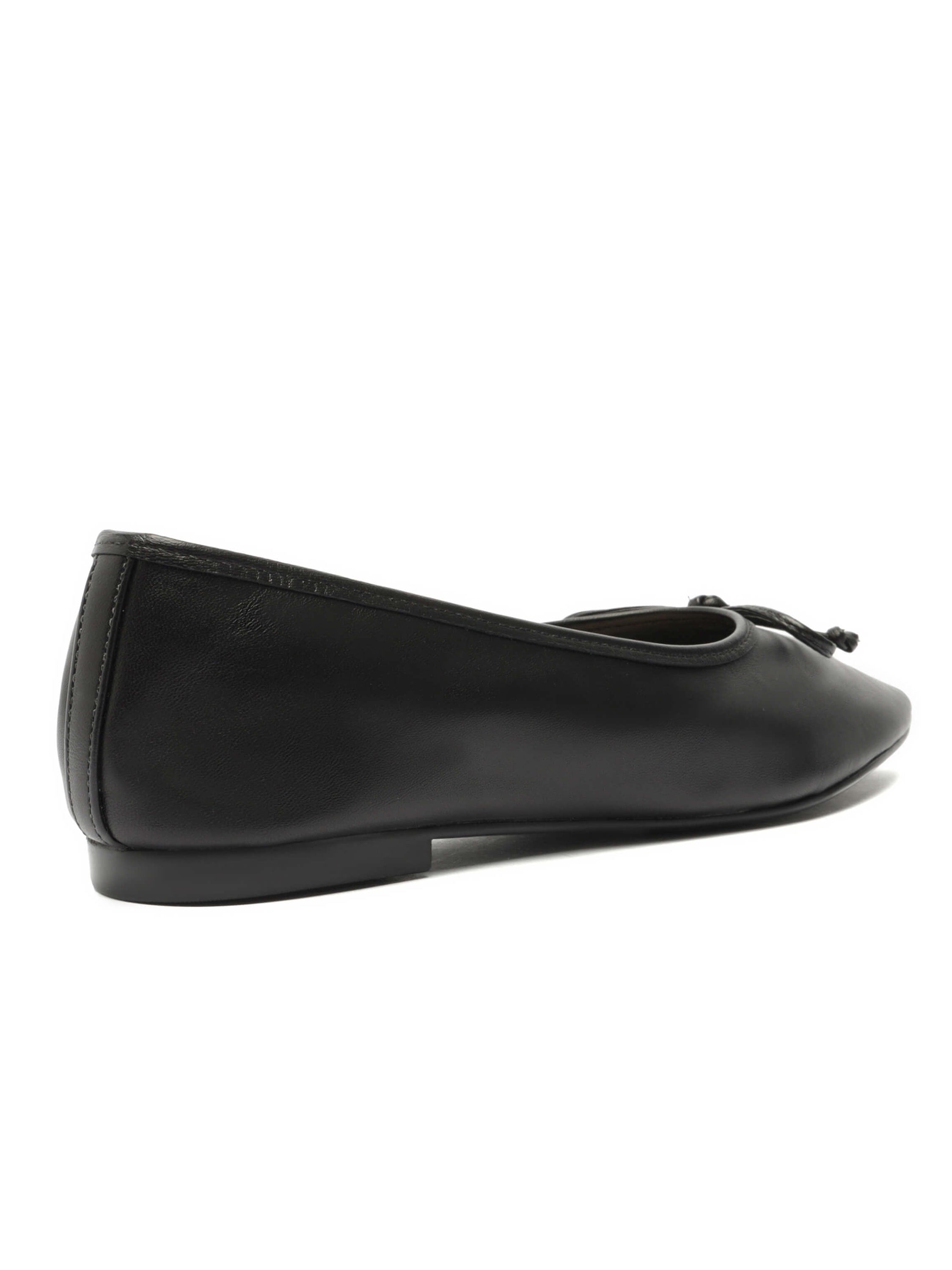 Classic black leather ballet flats feature a slight block heel, squared toe, and a decorative bow detail.