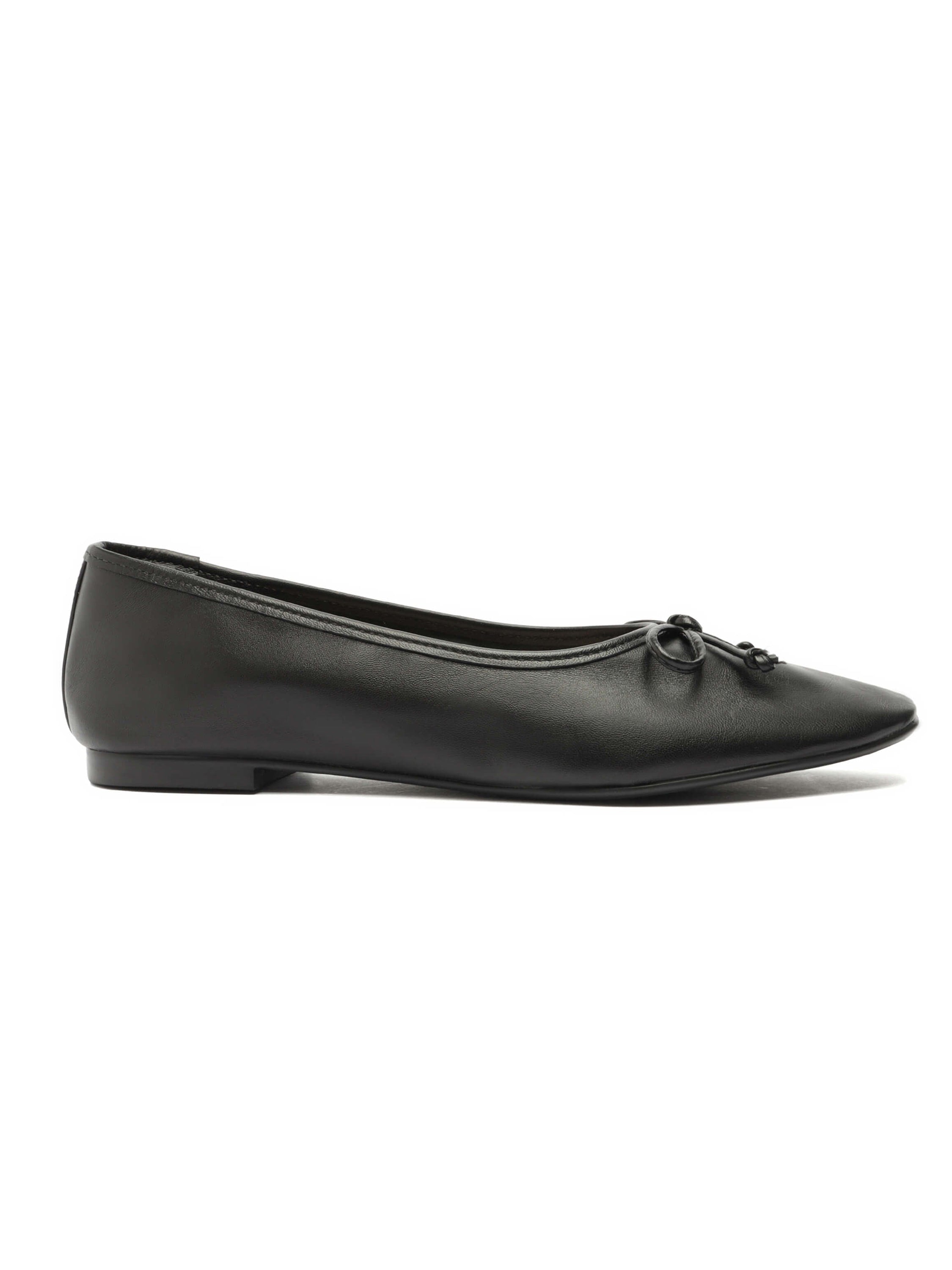 Black leather ballet flats feature a pointed toe and a small decorative bow detail on the front.