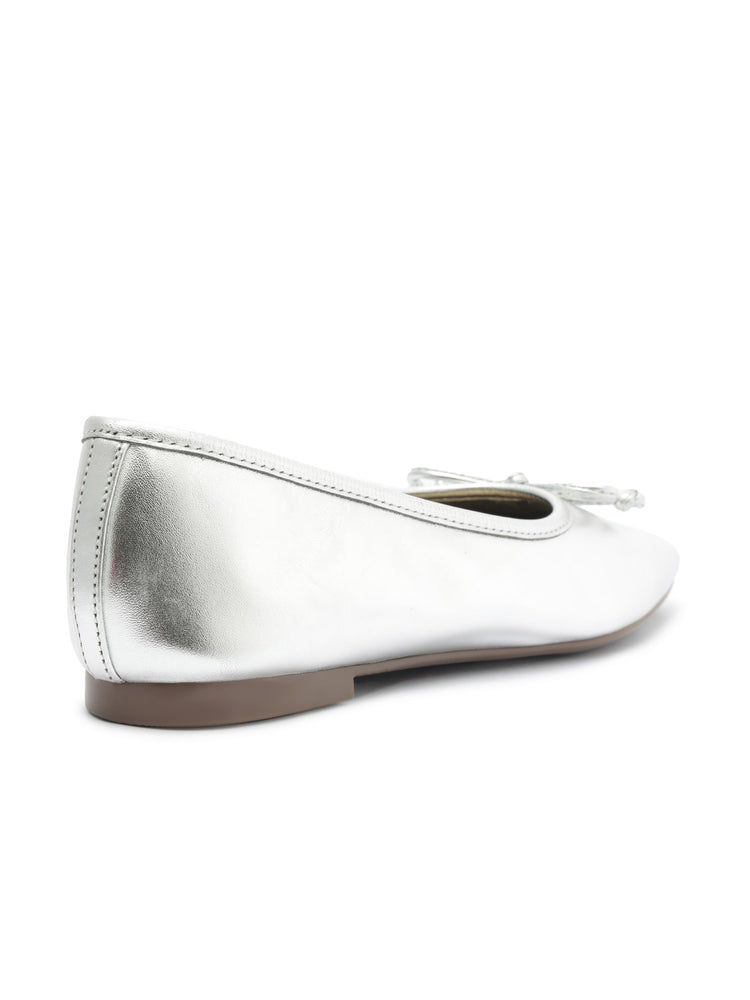 Silver metallic leather ballet flats featuring a rounded toe, minimal flat sole, and a tonal bow accent.