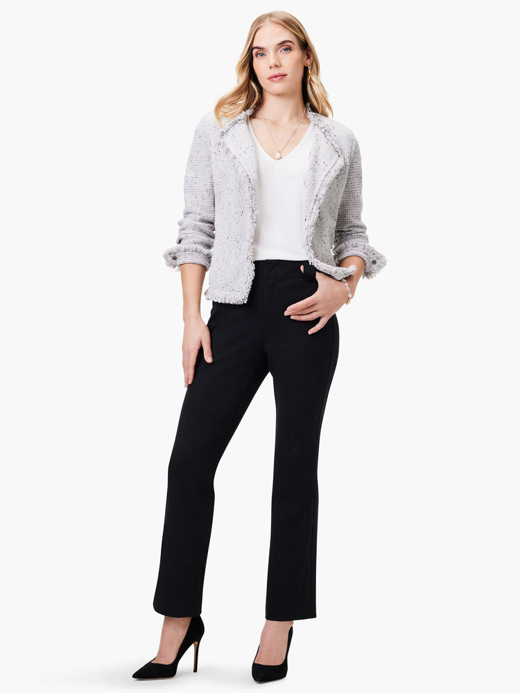 Gray tweed jacket with frayed edges, worn over a white shirt. Model also wears black pants and heels.
