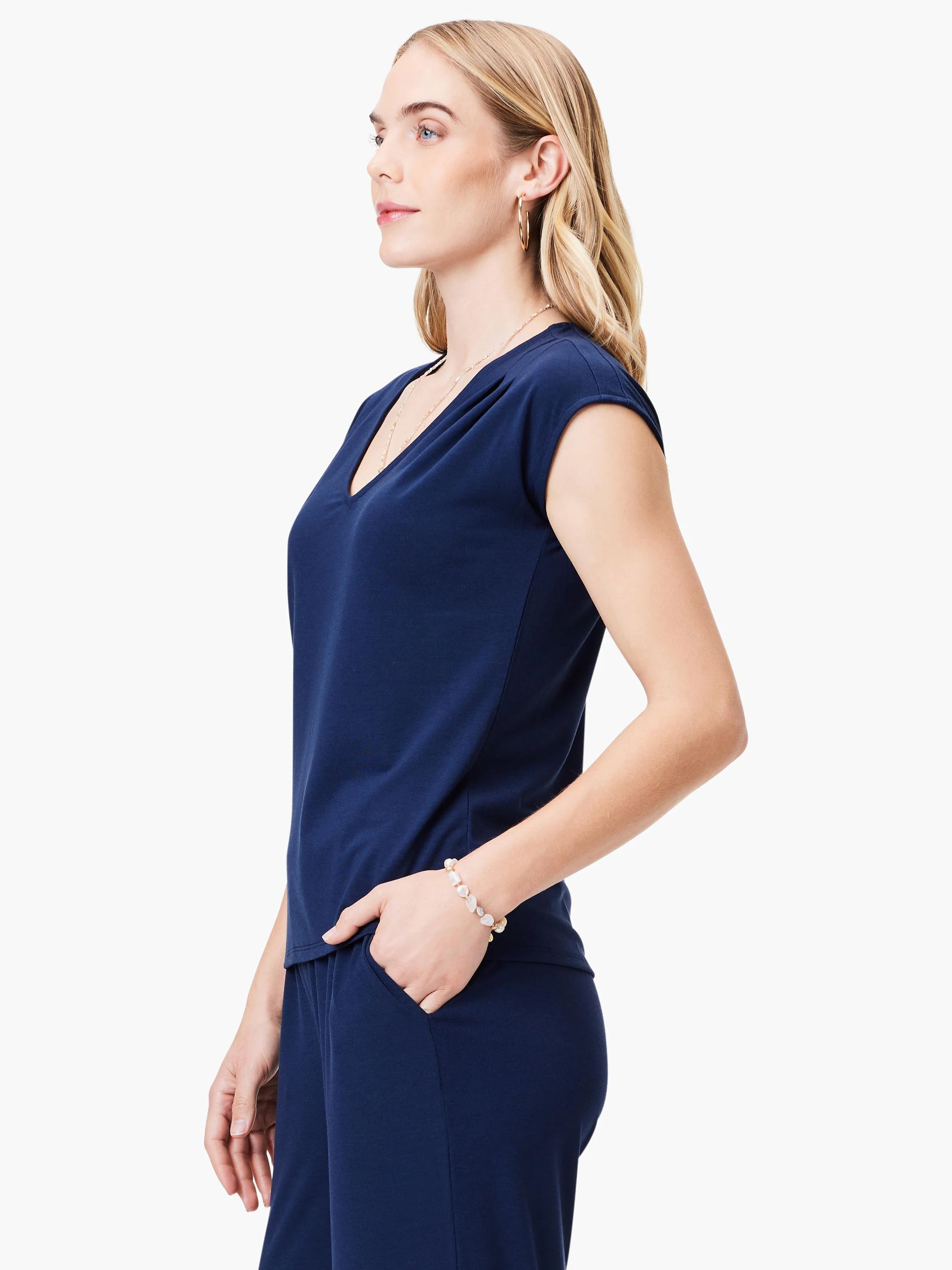Navy blue, short-sleeved v-neck top and pants. Side profile view.