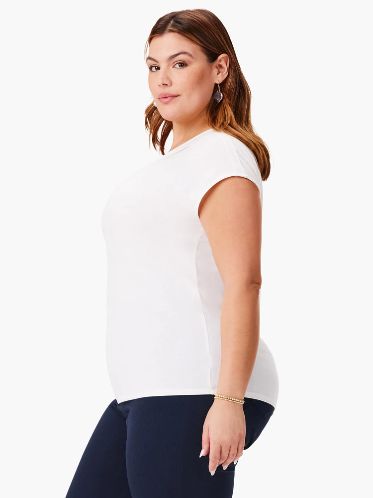 Off-white, short-sleeve, round-neck top. Model wears navy pants.