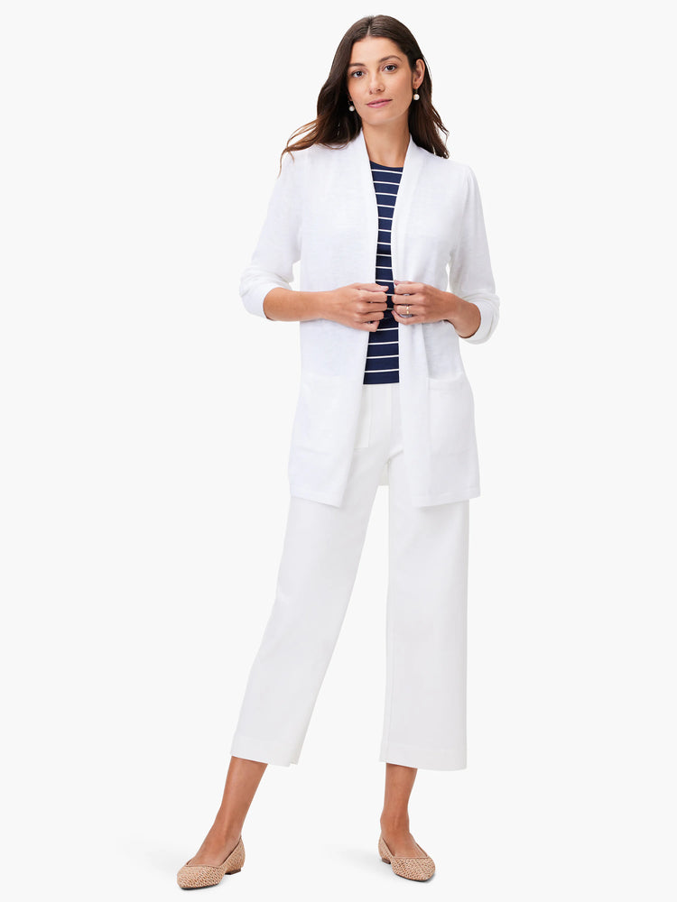 White open-front cardigan, ribbed knit texture. Features patch pockets. Model also wears a navy and white striped top...