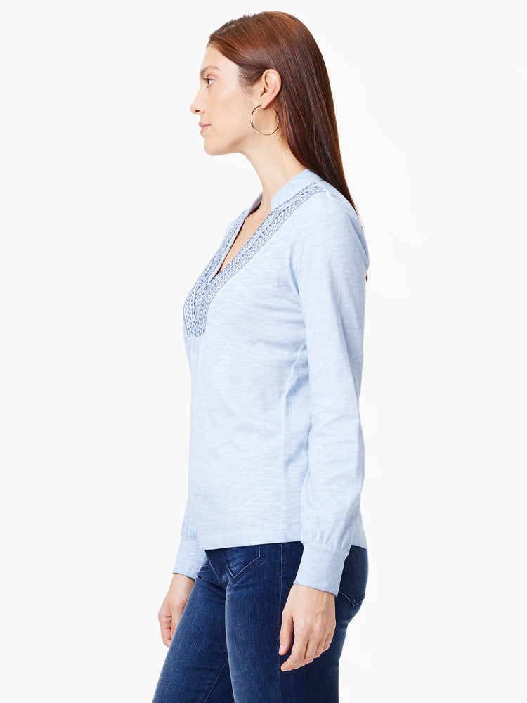 Light blue long-sleeve top with a V-neck and subtle embroidery detail at the neckline. The fabric appears soft.