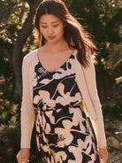 Beige ribbed cardigan.  Shown over a dark navy dress with a beige floral print.