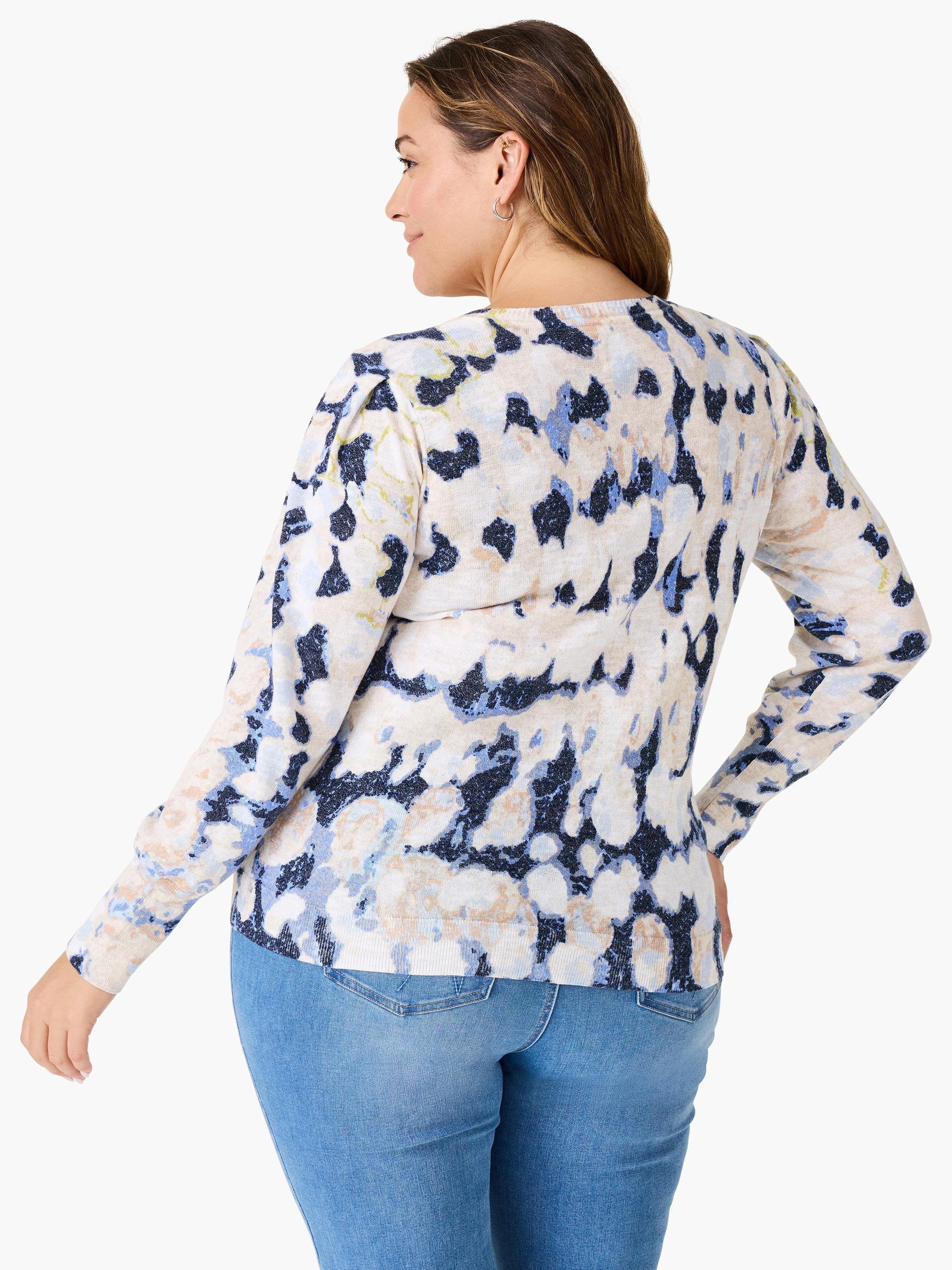 Cream-colored sweater with a blue and dark-navy abstract print. Long sleeves. Rear view.