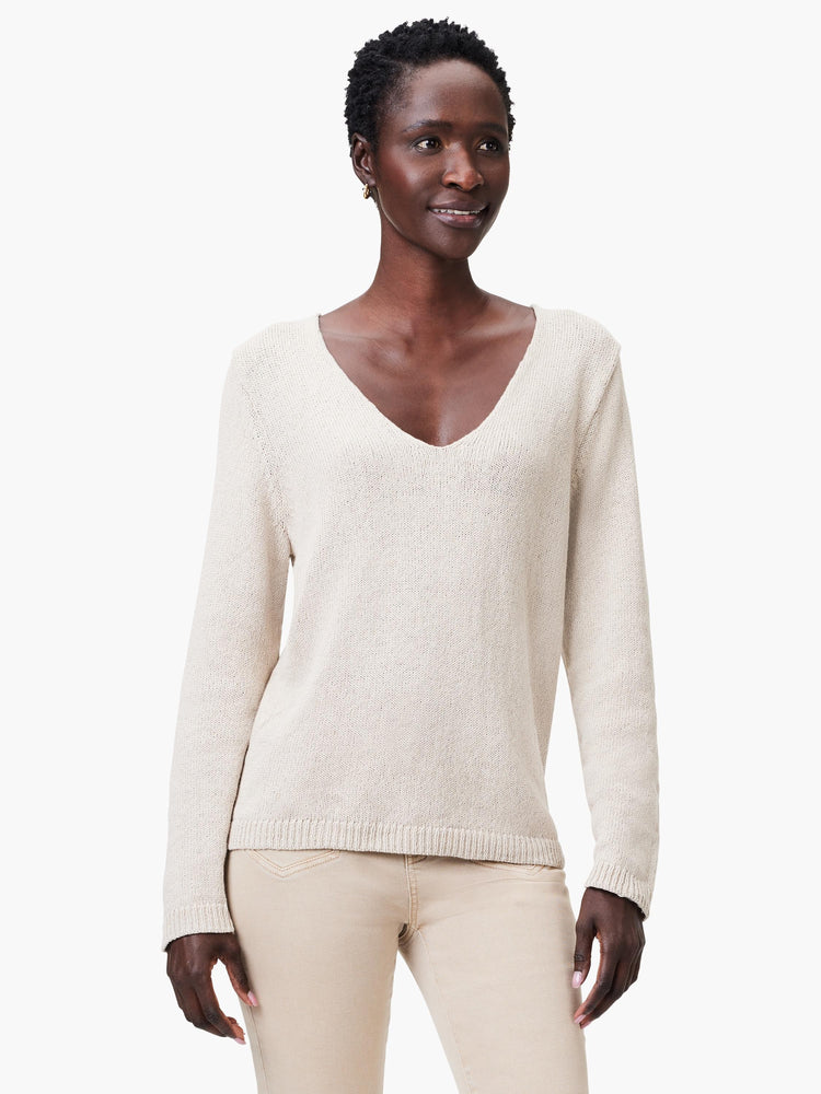 Light beige V-neck sweater with long sleeves, featuring a soft knit texture.
