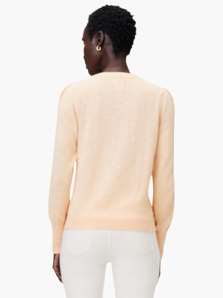Peach-colored slub V-neck sweater, long sleeves. Shown from the back.
