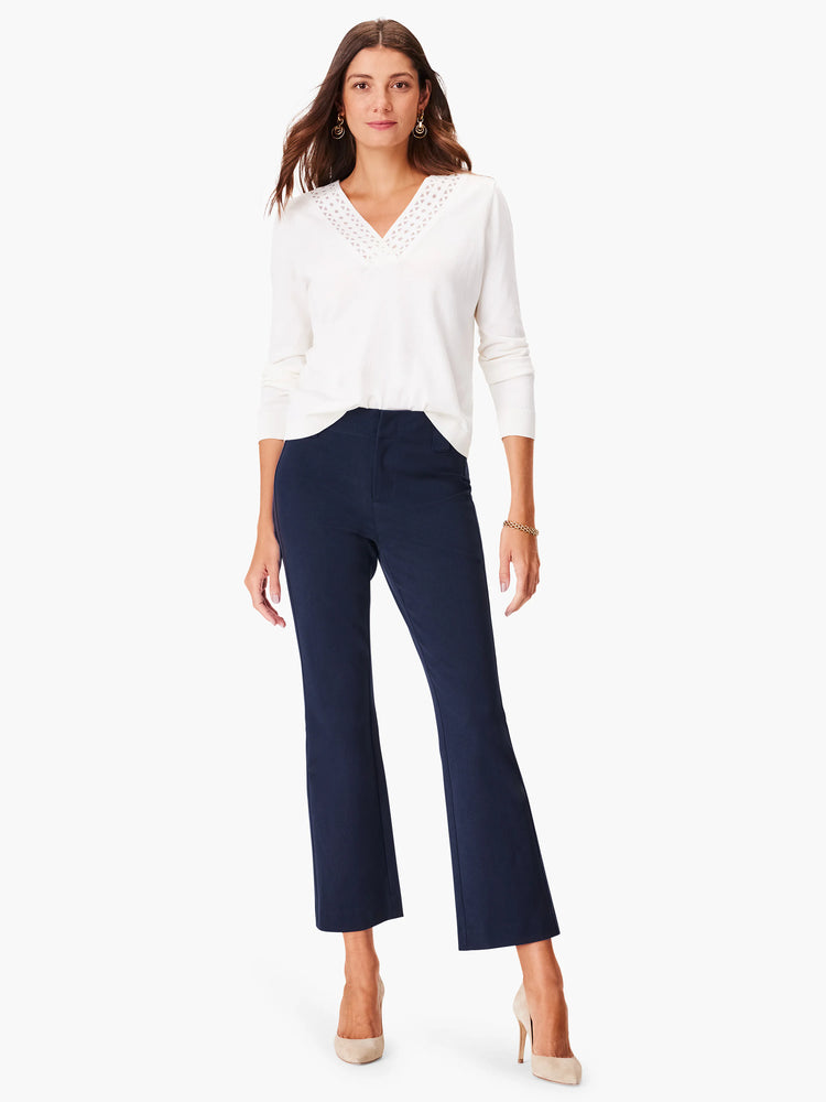 Off-white v-neck sweater with eyelet detail at neckline. Long sleeves.